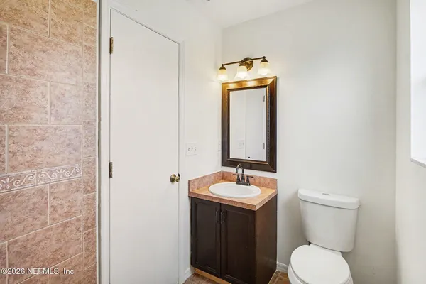 a bathroom with a toilet a sink and mirror