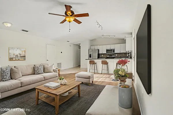 a living room with furniture and kitchen view