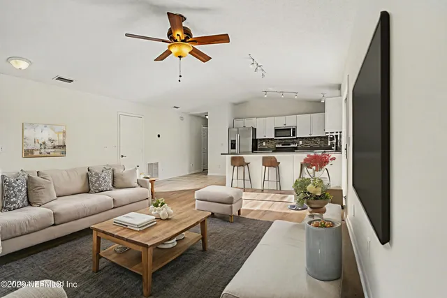 a living room with furniture and kitchen view