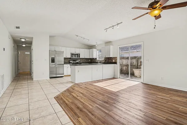 a large kitchen with stainless steel appliances kitchen island granite countertop a refrigerator and a sink
