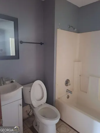a white toilet sitting next to a bath tub