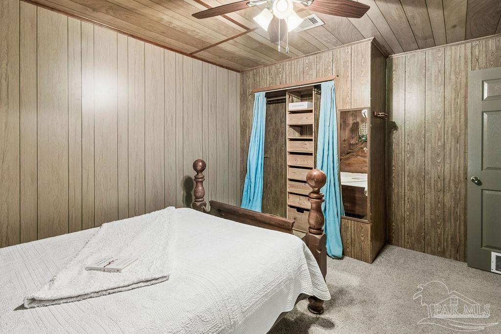 8938 Pioneer Road Holt, FL 32564 - Photo 26 of 44 a bedroom with a bed and a chandelier