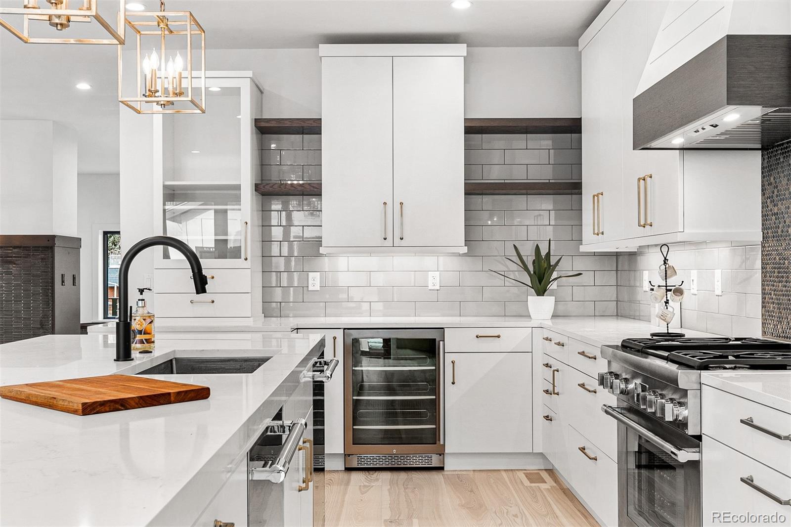 732 South Gilpin Street Denver, CO 80209 - Photo 20 of 40 a kitchen with stainless steel appliances a sink dishwasher stove and white cabinets with wooden floor