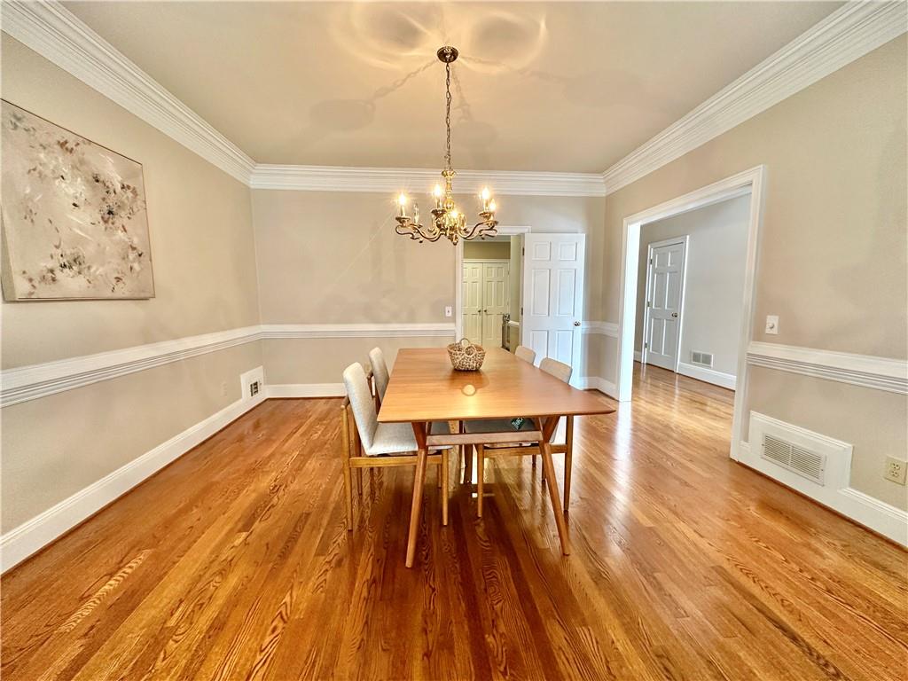 3510 Greystone Circle Atlanta, GA 30341 - Photo 5 of 29 a dining room with wooden floor a chandelier a glass table and chairs