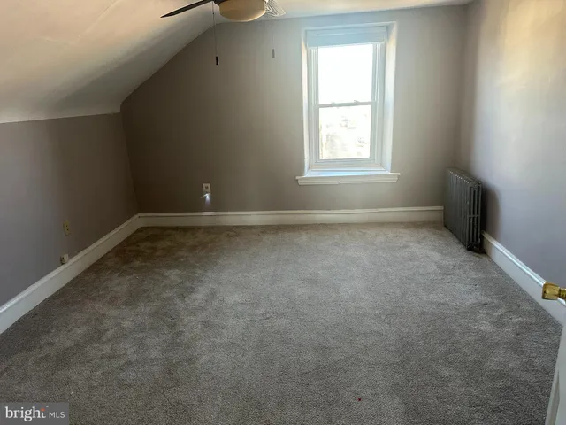 an empty room with wooden floor and entrance
