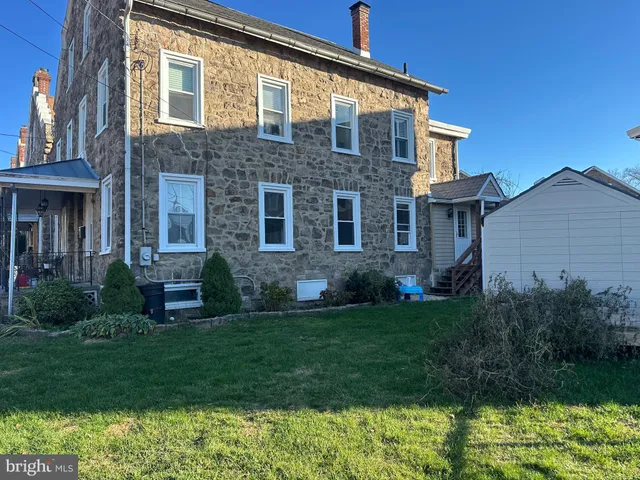 a view of a house with a big yard and sitting area