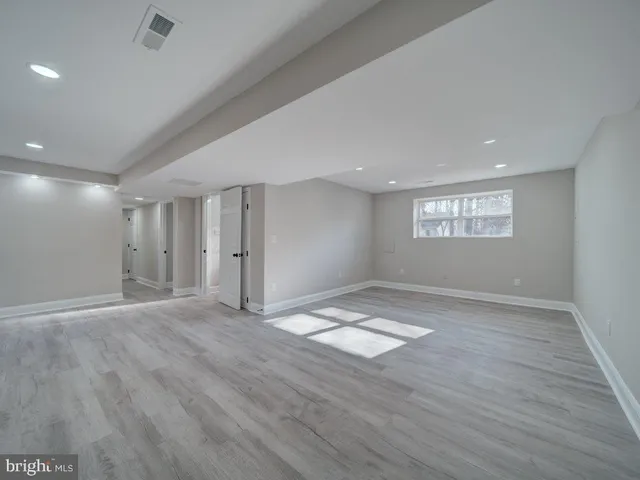 a view of empty room with wooden floor