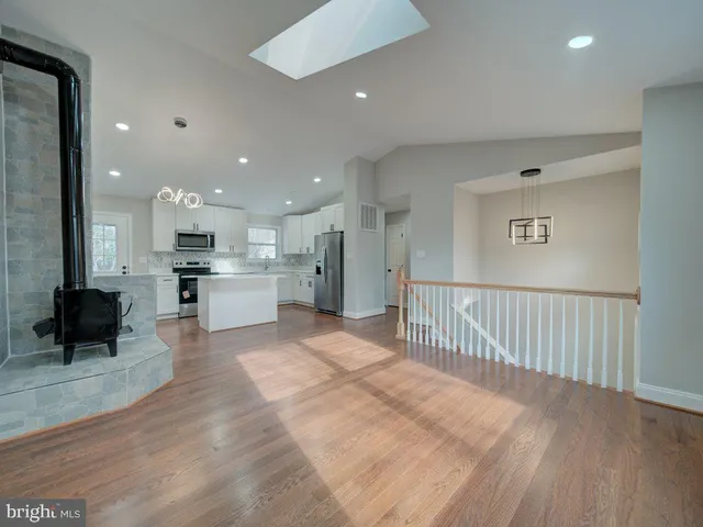 a view of a kitchen with kitchen island a window and a view of living room
