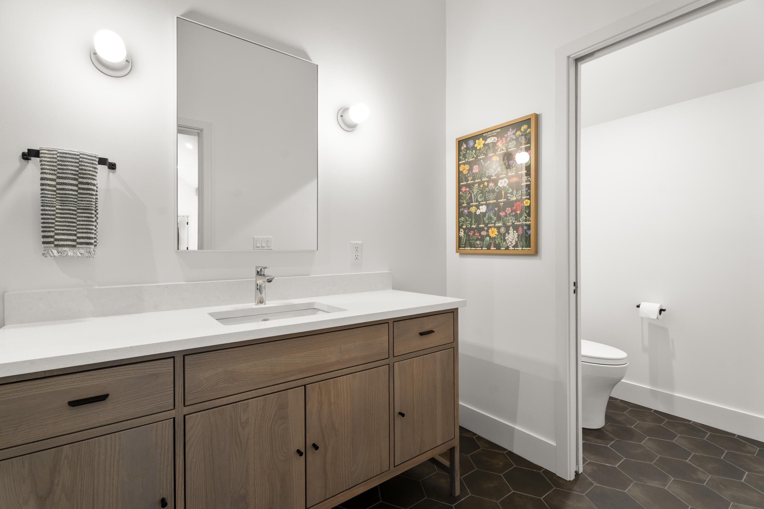 56670 Sunstone Loop, Unit LOT 141 Bend, OR 97707 - Photo 21 of 62 Bright bathroom adjacent to the loft with a single-sink stained wood vanity, soft-close storage, clean white surfaces, and tile floors.