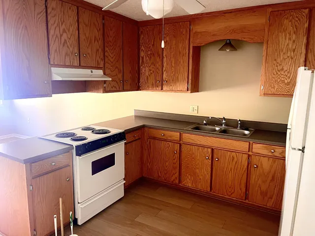 a kitchen with granite countertop a sink and a stove