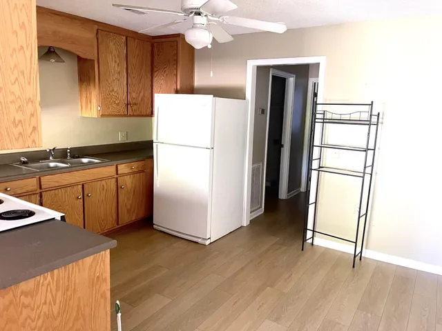 a kitchen with a refrigerator sink and cabinets