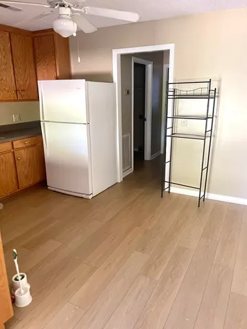 a view of a room with wooden floor and an empty room