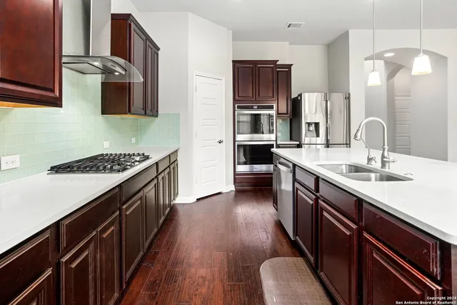 a kitchen with stainless steel appliances a sink stove and refrigerator