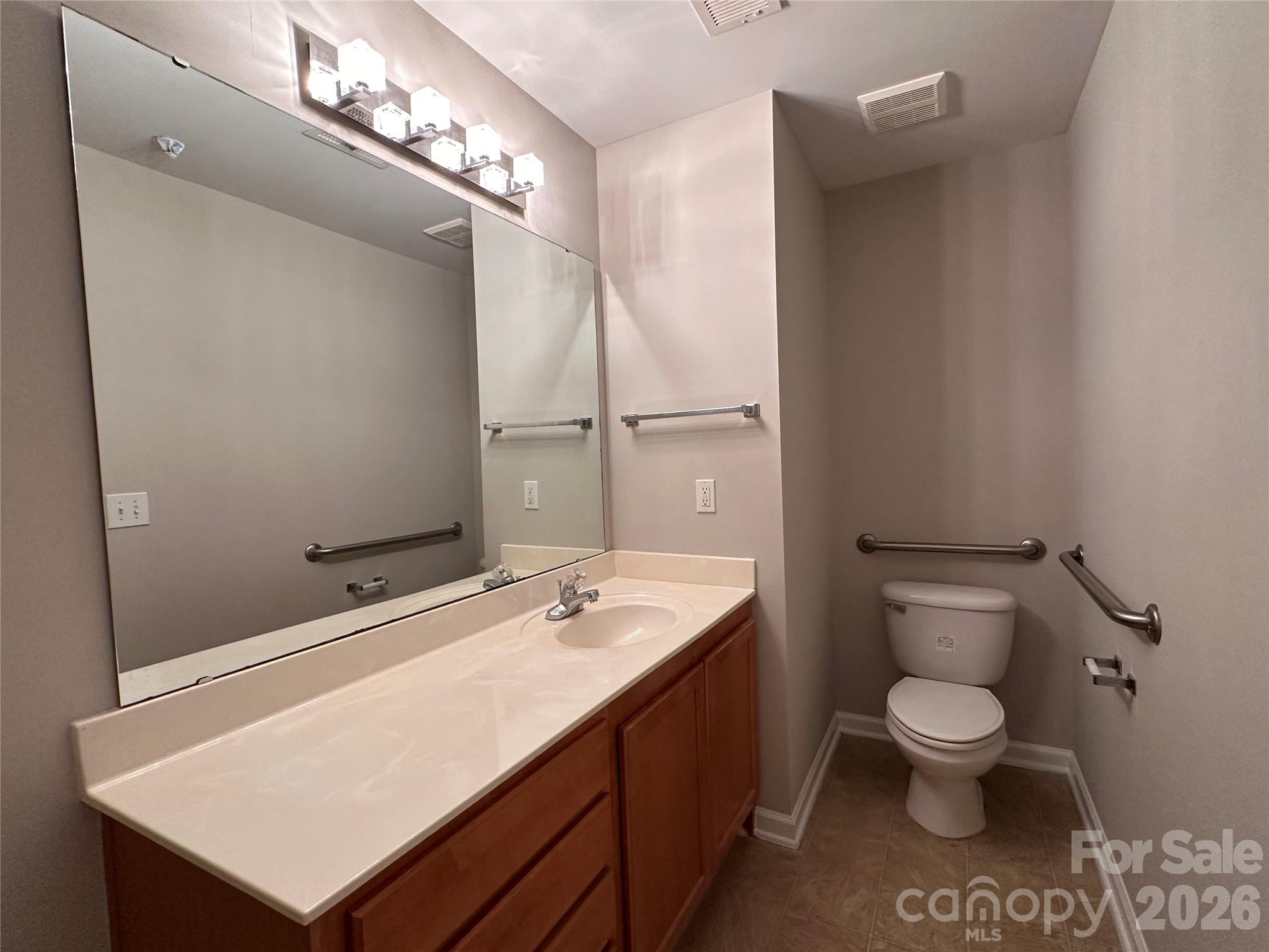 5236 Hilltop Road Jamestown, NC 27282 - Photo 21 of 32 a bathroom with a sink a toilet and a mirror