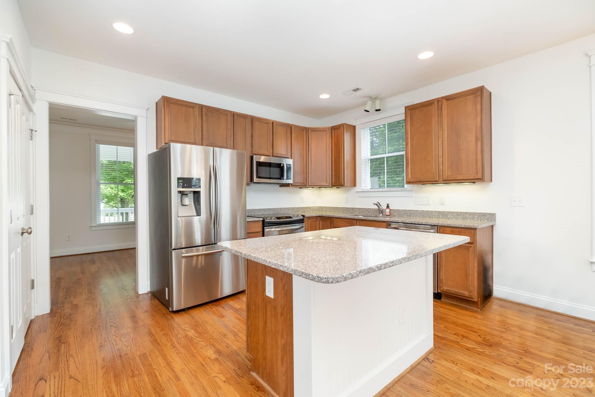 3499 Richard's Crossing Fort Mill, SC 29708 - Photo 12 of 33 a kitchen with stainless steel appliances granite countertop a refrigerator a sink dishwasher a stove with wooden floors