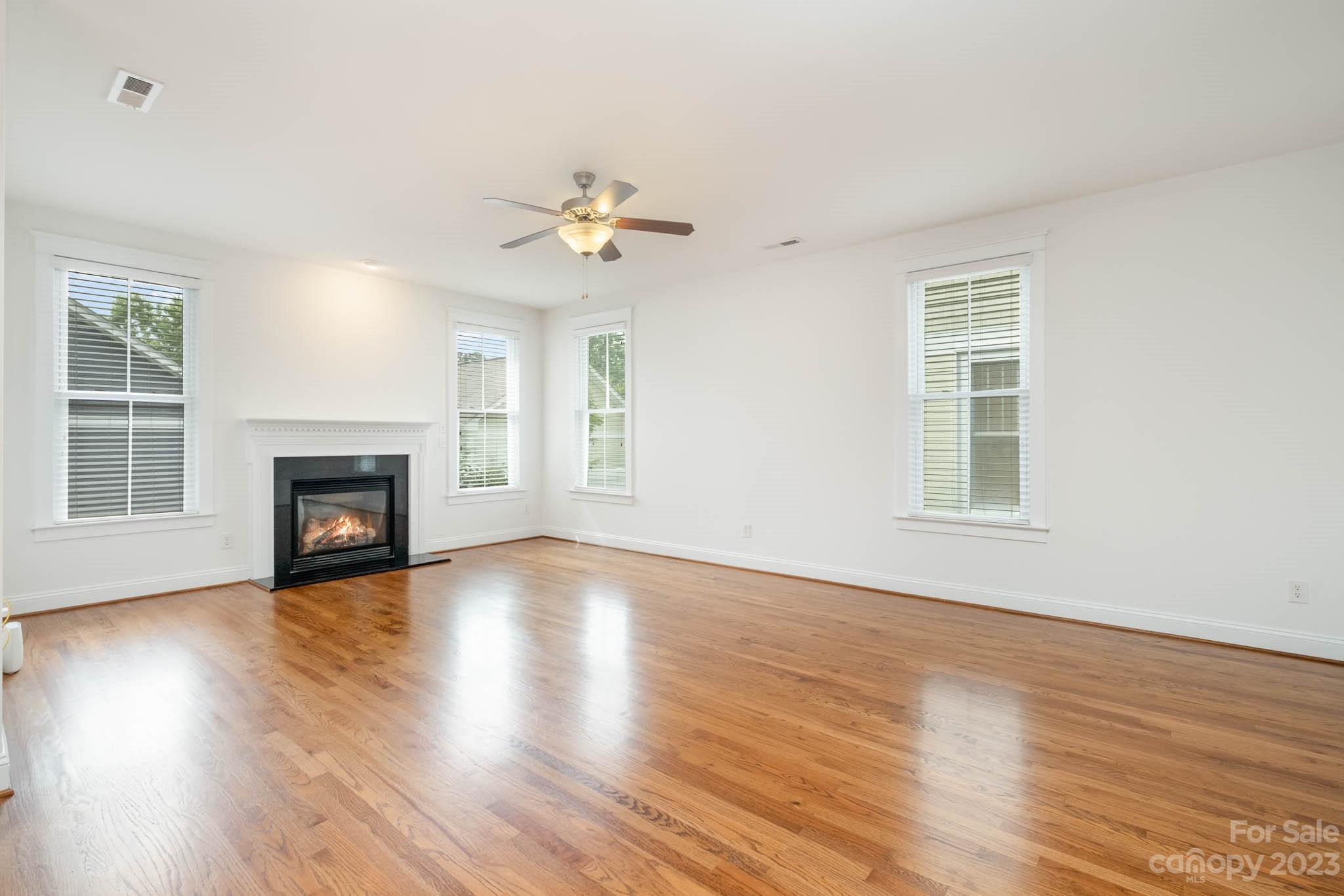 3499 Richard's Crossing Fort Mill, SC 29708 - Photo 8 of 33 an empty room with wooden floor fireplace and windows