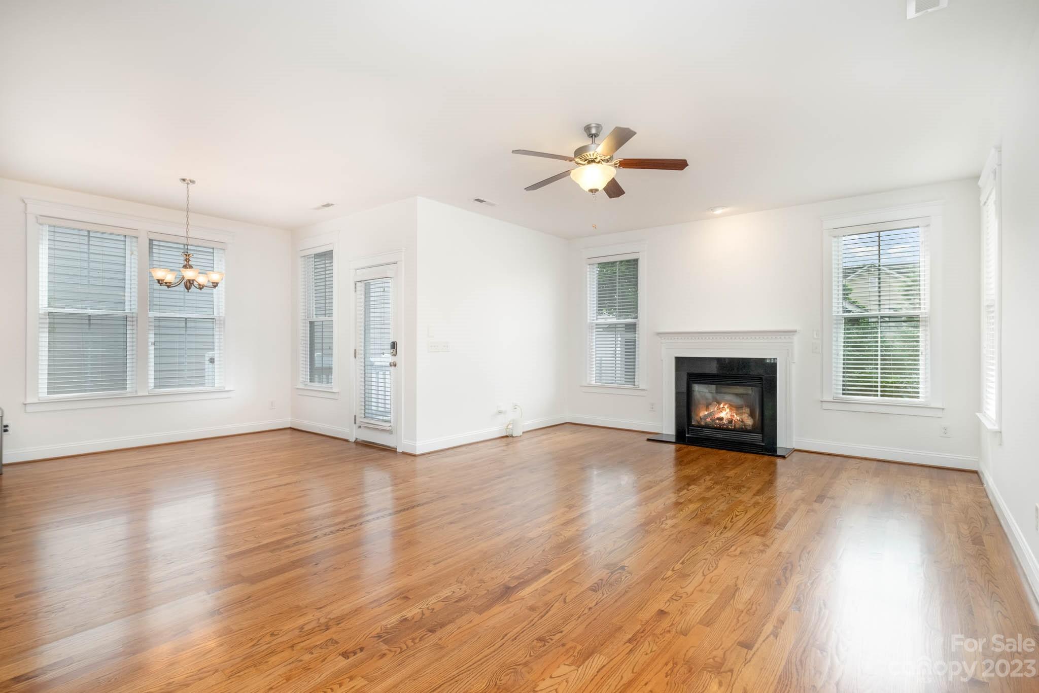 3499 Richard's Crossing Fort Mill, SC 29708 - Photo 9 of 33 an empty room with wooden floor fireplace and windows
