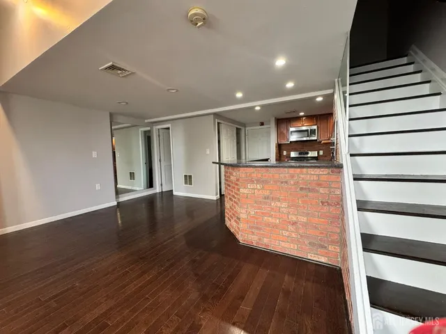 a view of a kitchen with furniture and wooden floor
