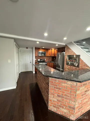 a large kitchen with stainless steel appliances kitchen island granite countertop a large counter top and stove