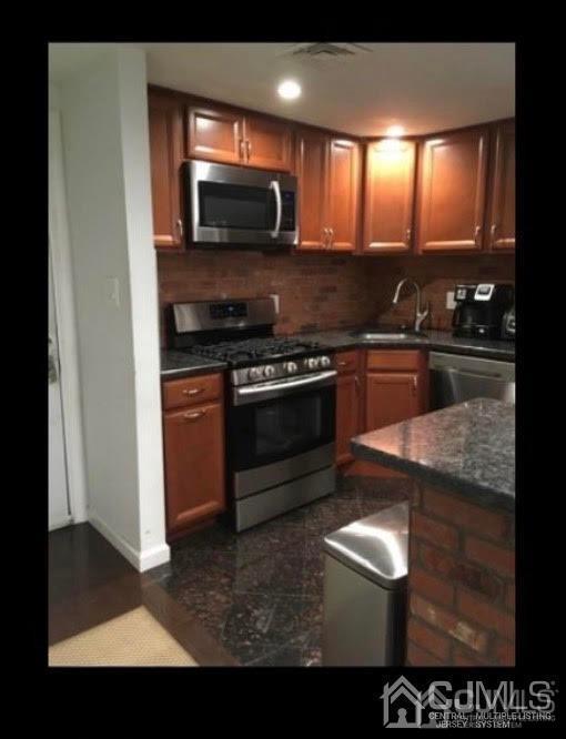 16 Jaques Street, Unit 22 Elizabeth, NJ 07201 - Photo 5 of 27 a kitchen with stainless steel appliances granite countertop a stove a sink and a microwave