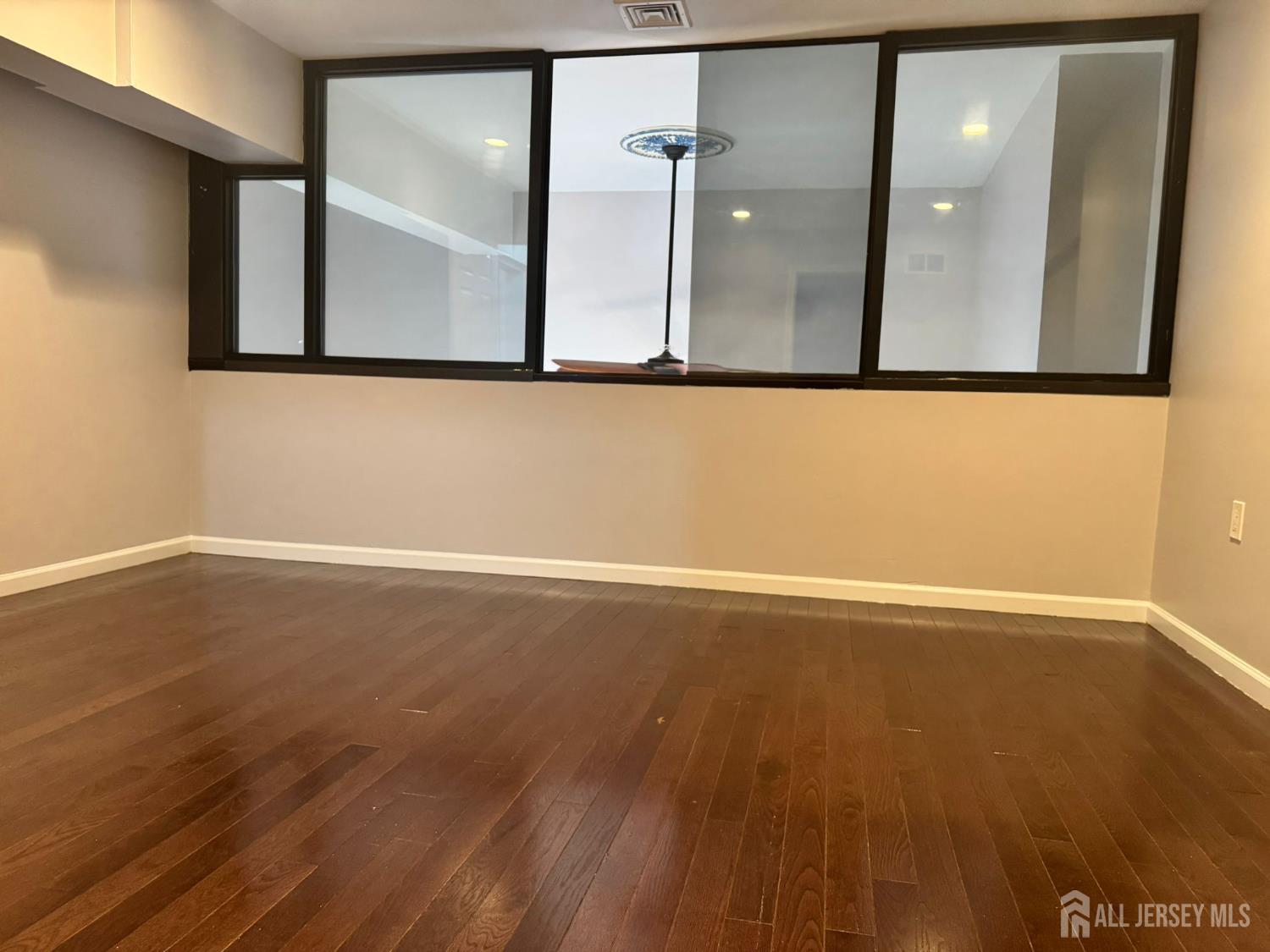 16 Jaques Street, Unit 22 Elizabeth, NJ 07201 - Photo 10 of 27 a view of a room with wooden floor and mirror