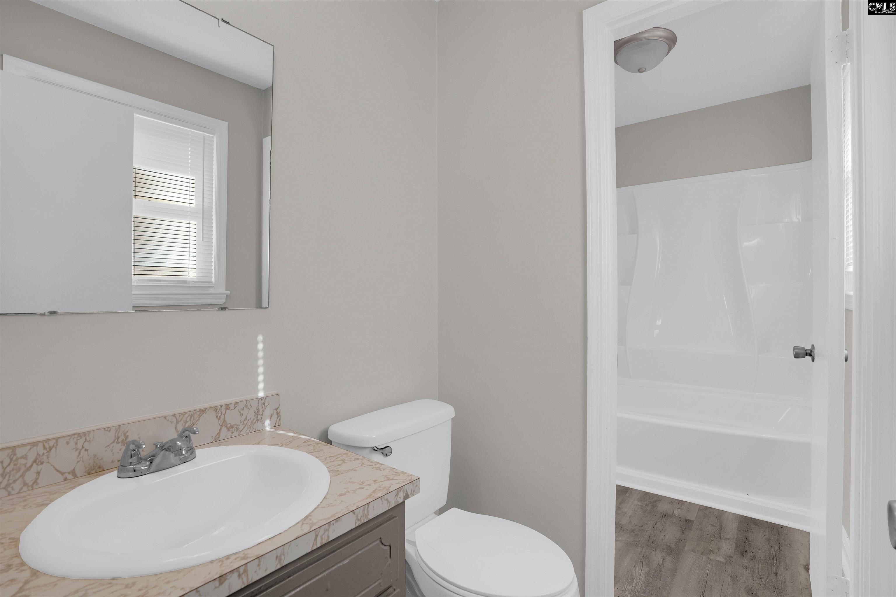 2620 Pleasant Ridge Drive Columbia, SC 29209 - Photo 26 of 37 a bathroom with a toilet a sink and mirror