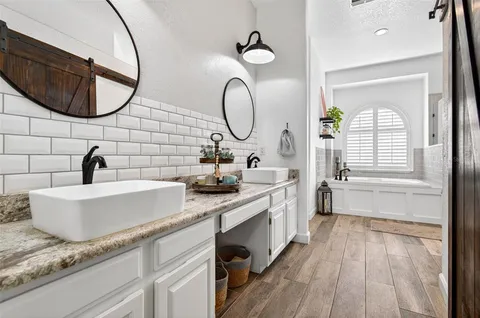 a spacious bathroom with a granite countertop sink mirror and bathtub