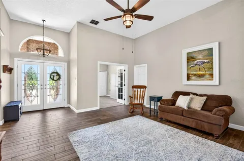 a living room with furniture a chandelier and a window