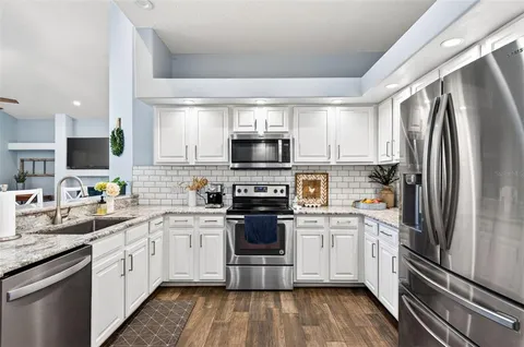 a kitchen with a white stainless steel appliances and white cabinets