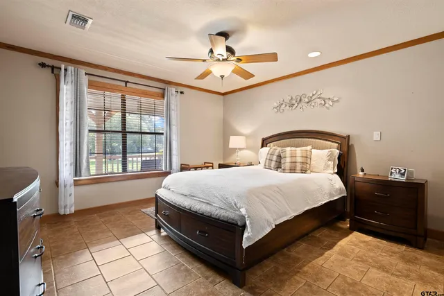 a spacious bedroom with a bed and a chandelier