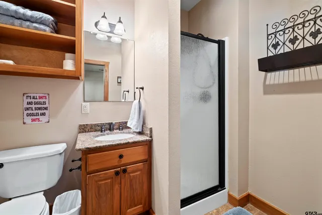 a bathroom with a granite countertop sink toilet and shower