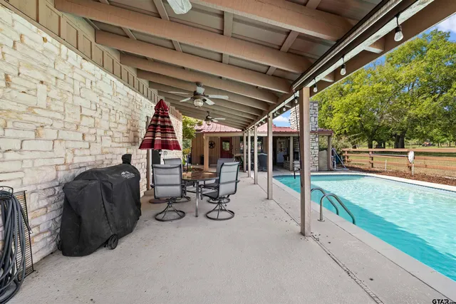 a view of a chairs and table in patio with a barbeque