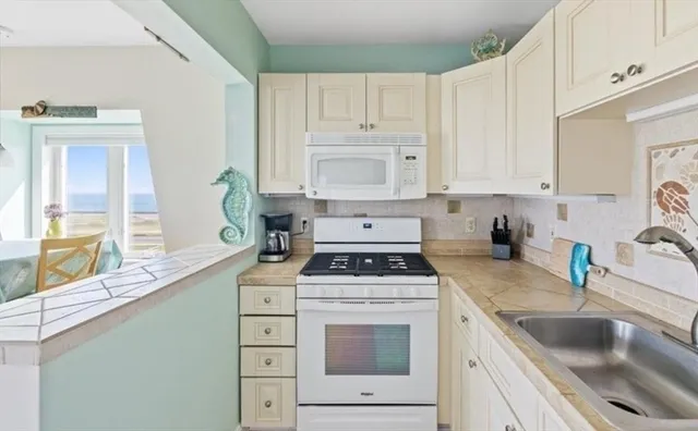 a kitchen with cabinets appliances a sink and a window