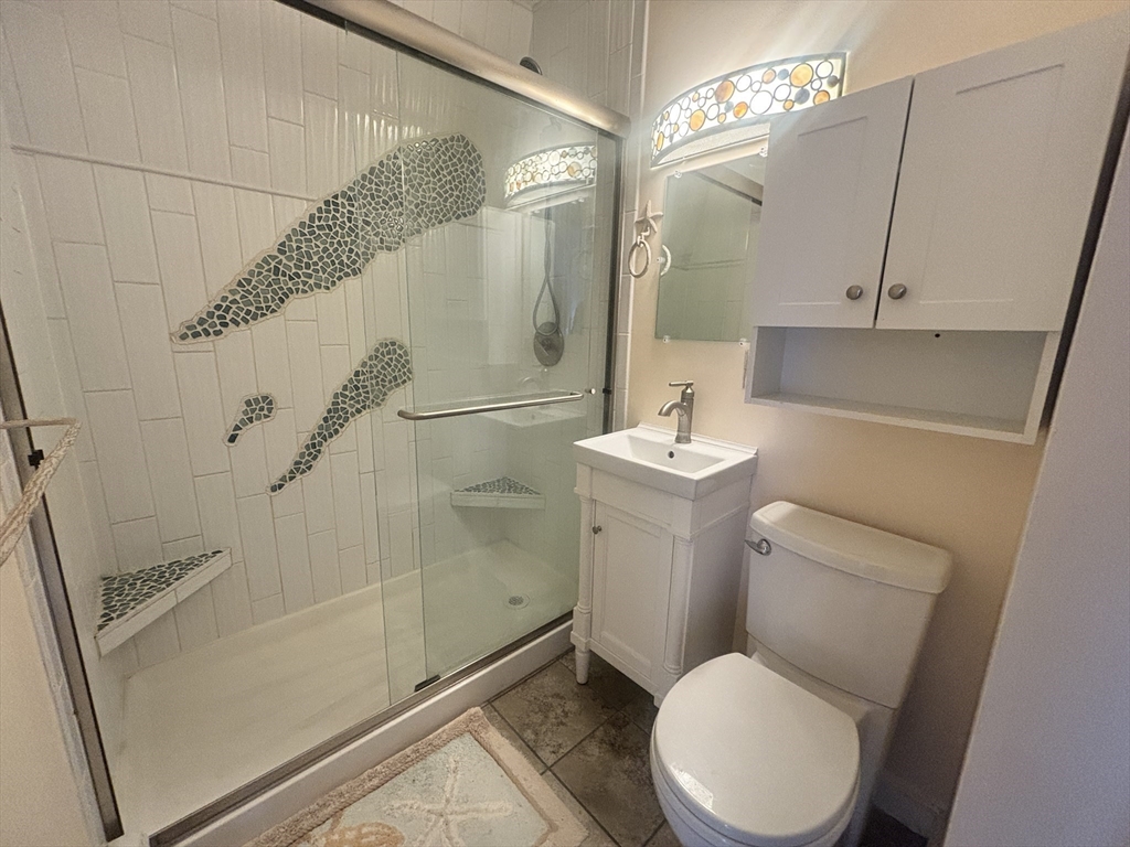 132 Bay Street, Unit 8 Hull, MA 02045 - Photo 6 of 8 a white toilet sitting next to a bathroom sink