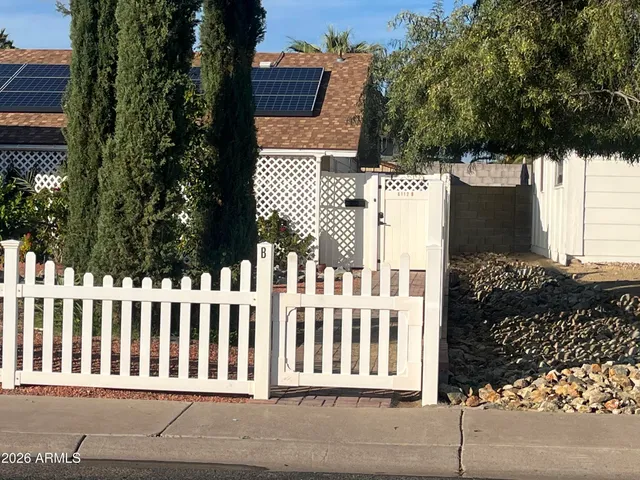 a view of a house with a small yard and wooden fence