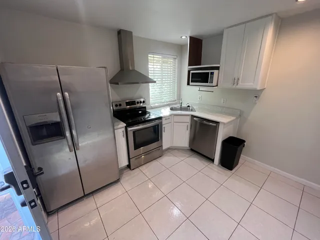 a kitchen with stainless steel appliances a stove a sink and a refrigerator