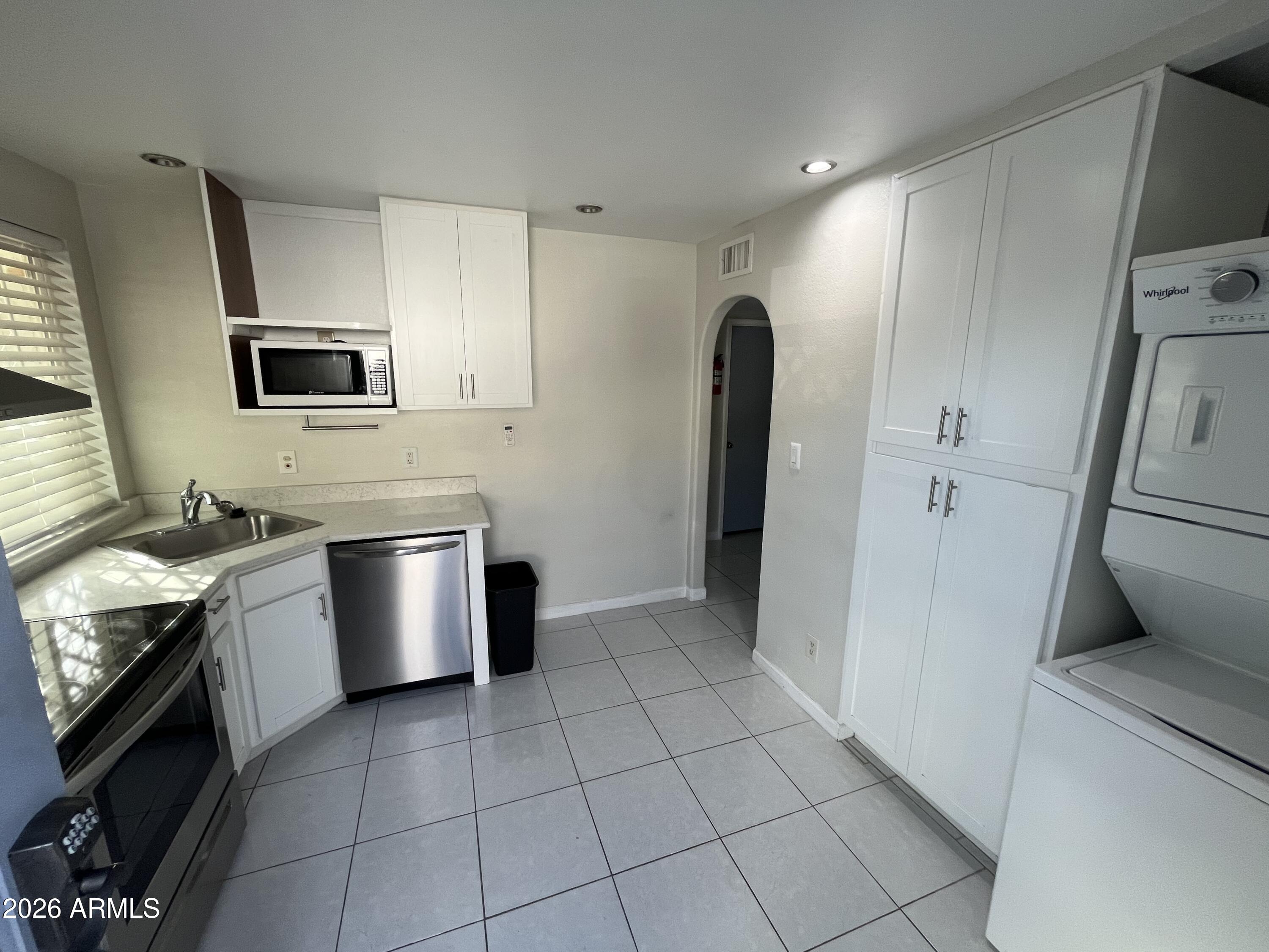 4112 West Hearn Road Phoenix, AZ 85053 - Photo 5 of 13 a kitchen with stainless steel appliances a stove a sink and a refrigerator