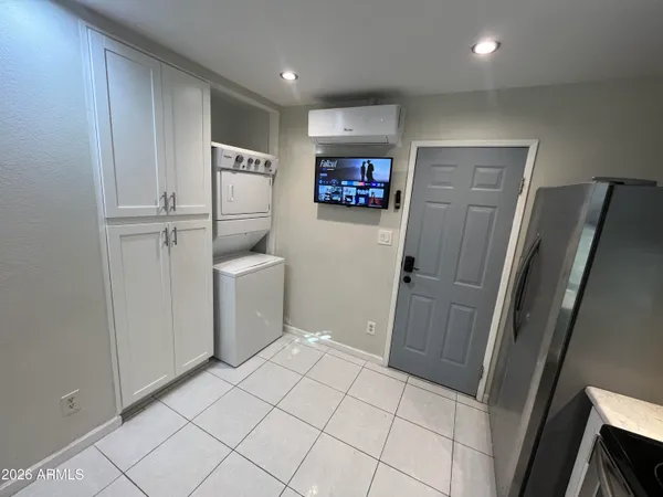 a utility room with refrigerator and washer