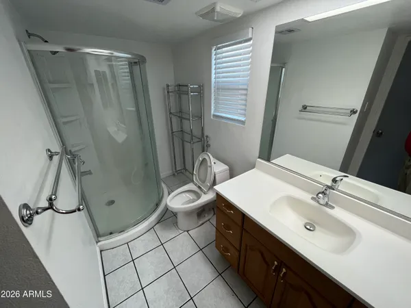 a bathroom with a sink a toilet a mirror and shower