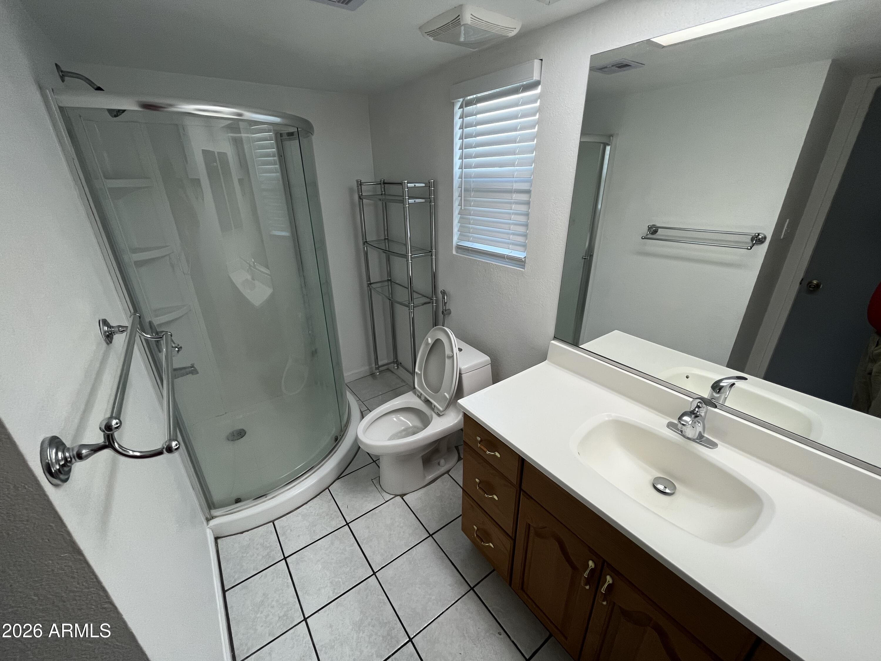 4112 West Hearn Road Phoenix, AZ 85053 - Photo 10 of 13 a bathroom with a sink a toilet a mirror and shower
