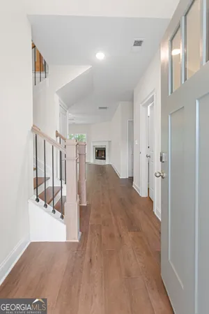 an empty room with wooden floor chandelier fan and windows