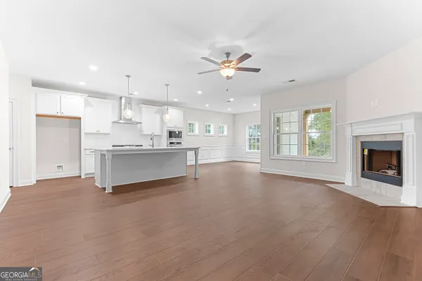 a large kitchen with kitchen island a sink stainless steel appliances and a chandelier