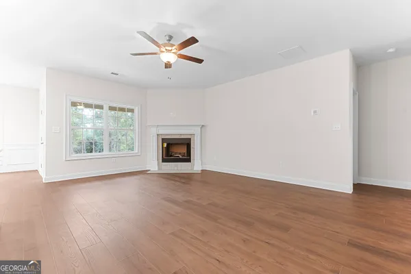 a kitchen with stainless steel appliances a sink a stove a refrigerator and white cabinets with wooden floor