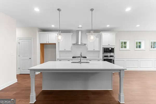 a kitchen with granite countertop white cabinets and appliances