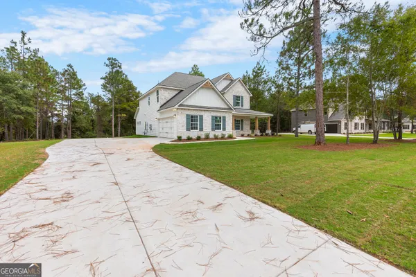 a front view of a house with a yard and trees