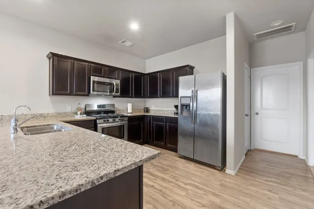 a kitchen with stainless steel appliances kitchen island cabinets and chair
