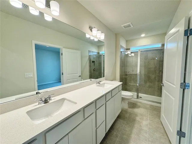 a bathroom with a double vanity sink mirror and shower