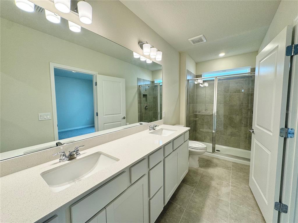 3703 Haddon Avenue Davenport, FL 33837 - Photo 13 of 23 a bathroom with a double vanity sink mirror and shower