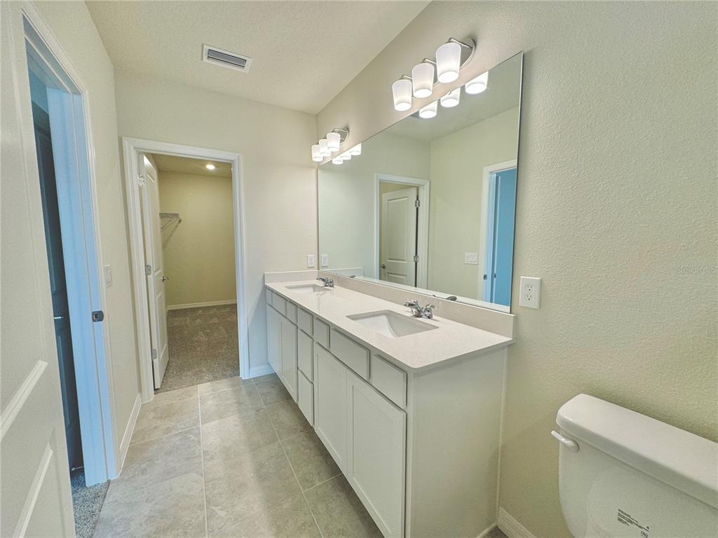 3703 Haddon Avenue Davenport, FL 33837 - Photo 14 of 23 a bathroom with a sink a toilet and a mirror