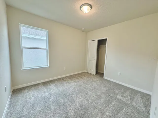 an empty room with closet and a window